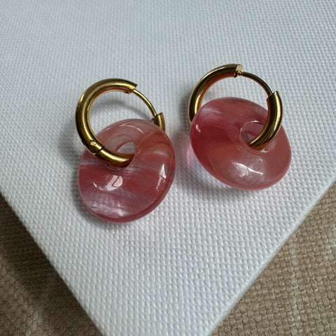 Gold hoops looped through large pink resin beads.