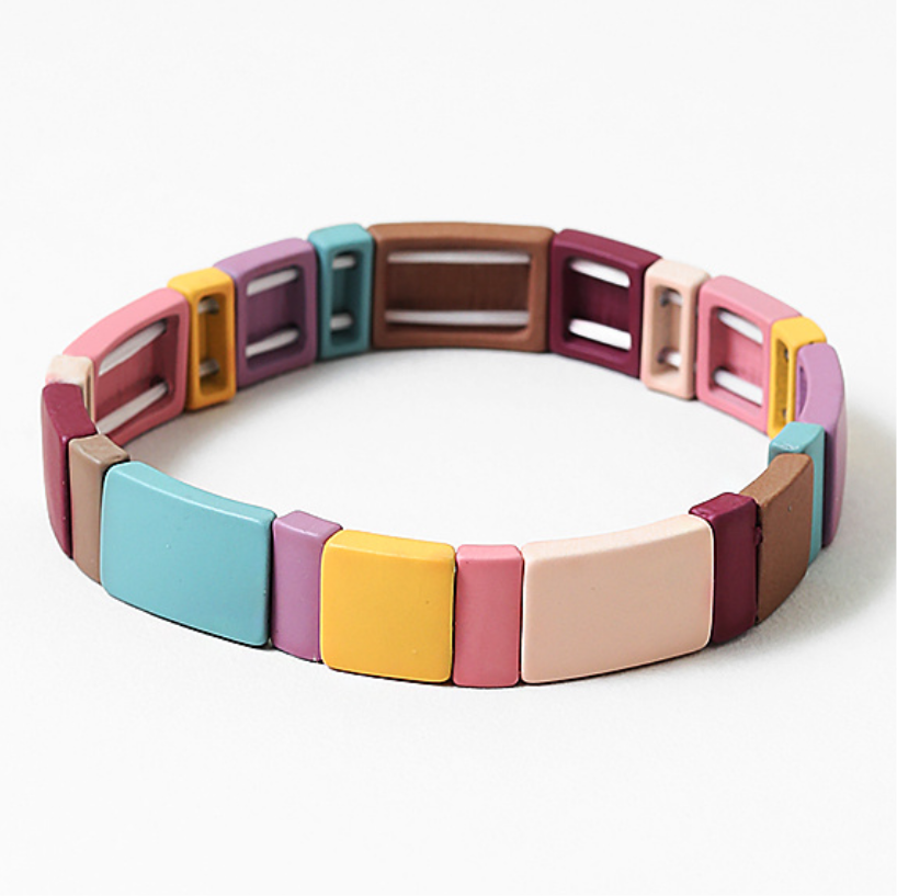 Colorful bracelet with square links in beige, browns, yellows, purples and blues on a white background