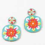 Colorful embroidered dangle earrings in turquoise, orange, coral and White on a white background