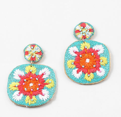 Colorful embroidered dangle earrings in turquoise, orange, coral and White on a white background