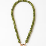 Green beaded necklace with a gold clasp on a white background