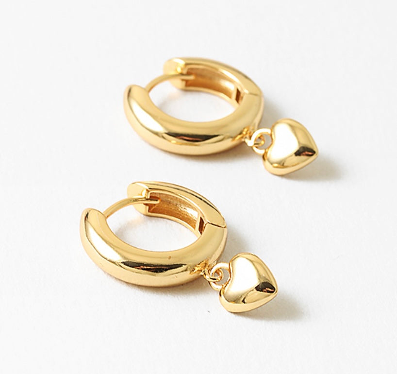 Gold hoop earrings with heart charms on a white background