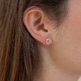 Picture model wearing a small smiley face gold stud.