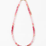 Necklace with pink beads and gold accents on a white background