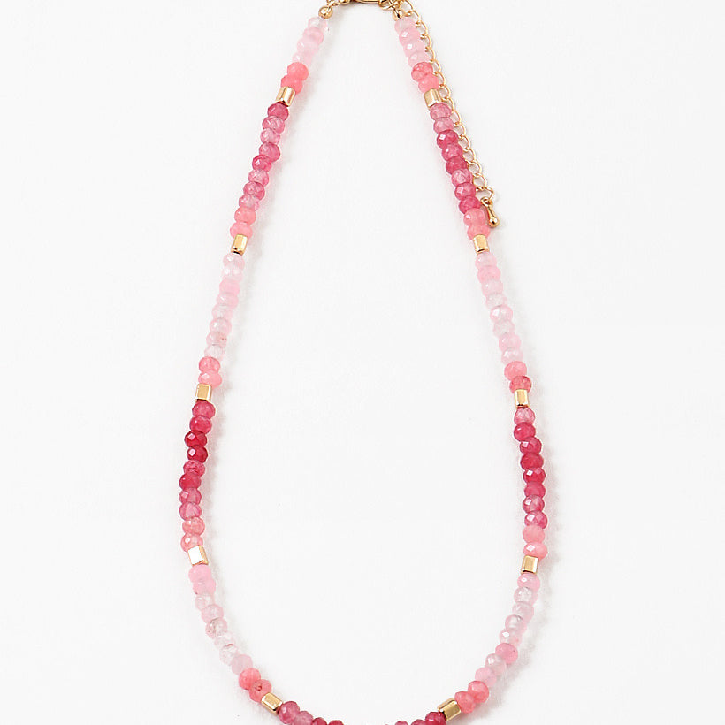 Necklace with pink beads and gold accents on a white background