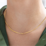 Model wearing dainty gold necklace with a petite knot in the center