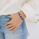 Picture of a woman's wrist displaying a bracelet in blue and pink beads.