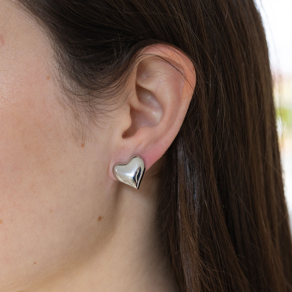 Model wearing small silver bubble heart stud.