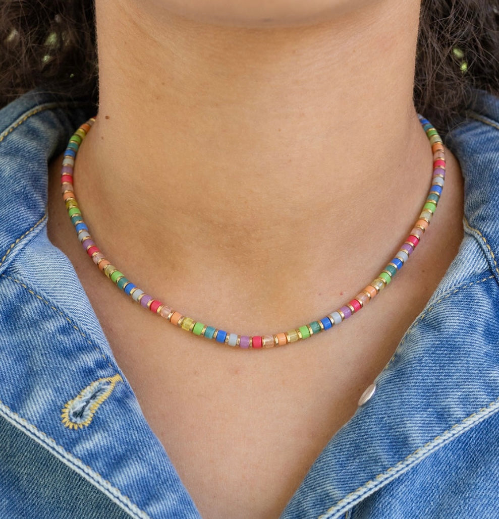 Colorful beaded necklace worn by a person with a denim jacket.