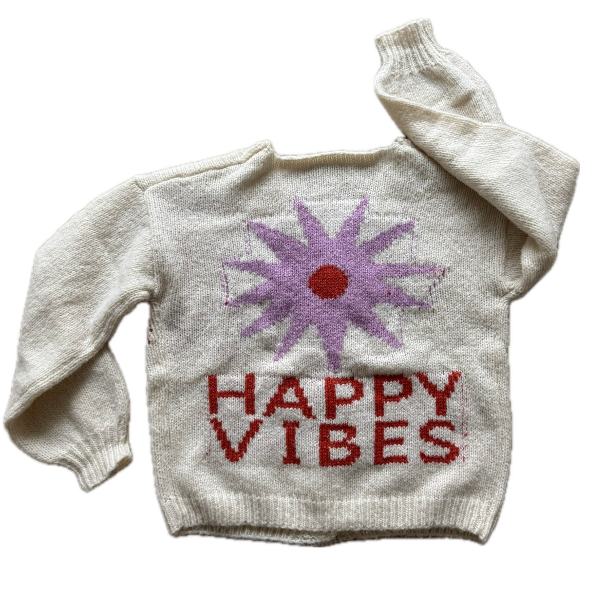 Picture of a cream colored sweater with a purple flower with a red center and red lettering that read, "Happy Vibes".