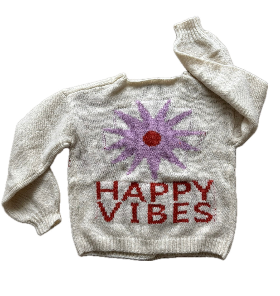 Picture of a cream colored sweater with a purple flower with a red center and red lettering that read, "Happy Vibes".