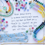 Advertisement showing many colorful beads and various necklaces with the text,"Never admire quietly. If we admire something about someone, let's tell them. We humans are so fragile. It's important we give people their flowers while they are still here."