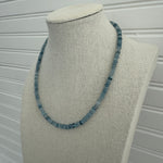 Picture of display showing a slate blue bead necklace in varying shades.