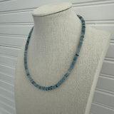 Picture of display showing a slate blue bead necklace in varying shades.