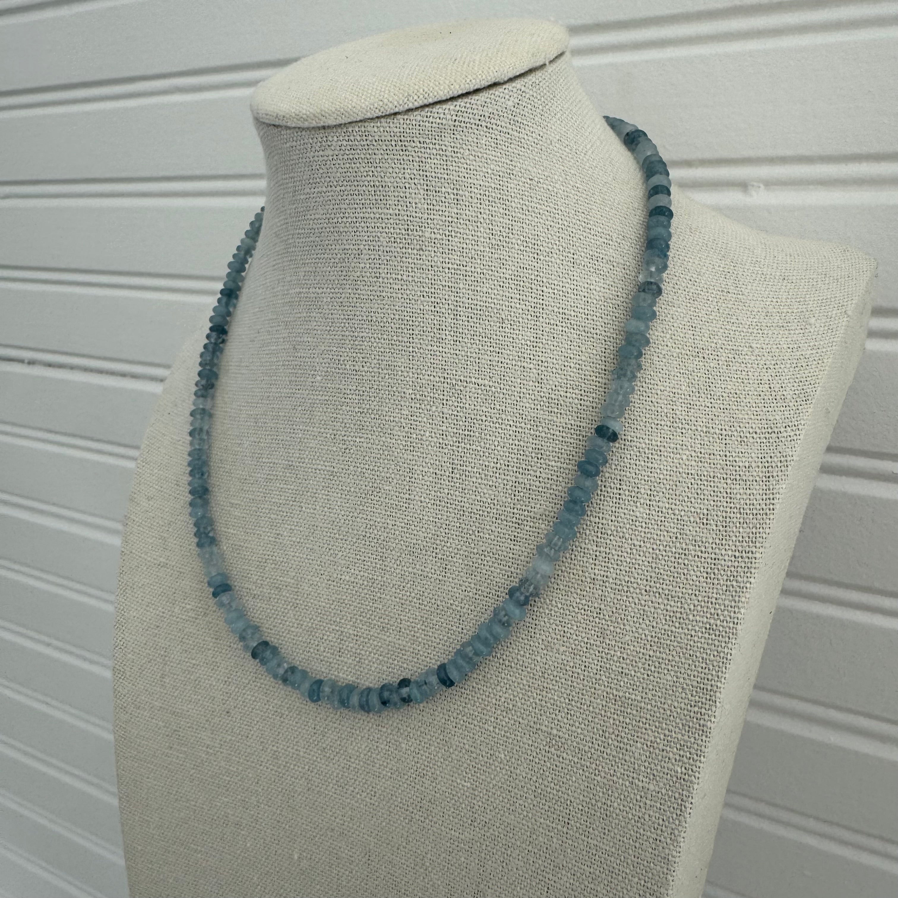Picture of display showing a slate blue bead necklace in varying shades.