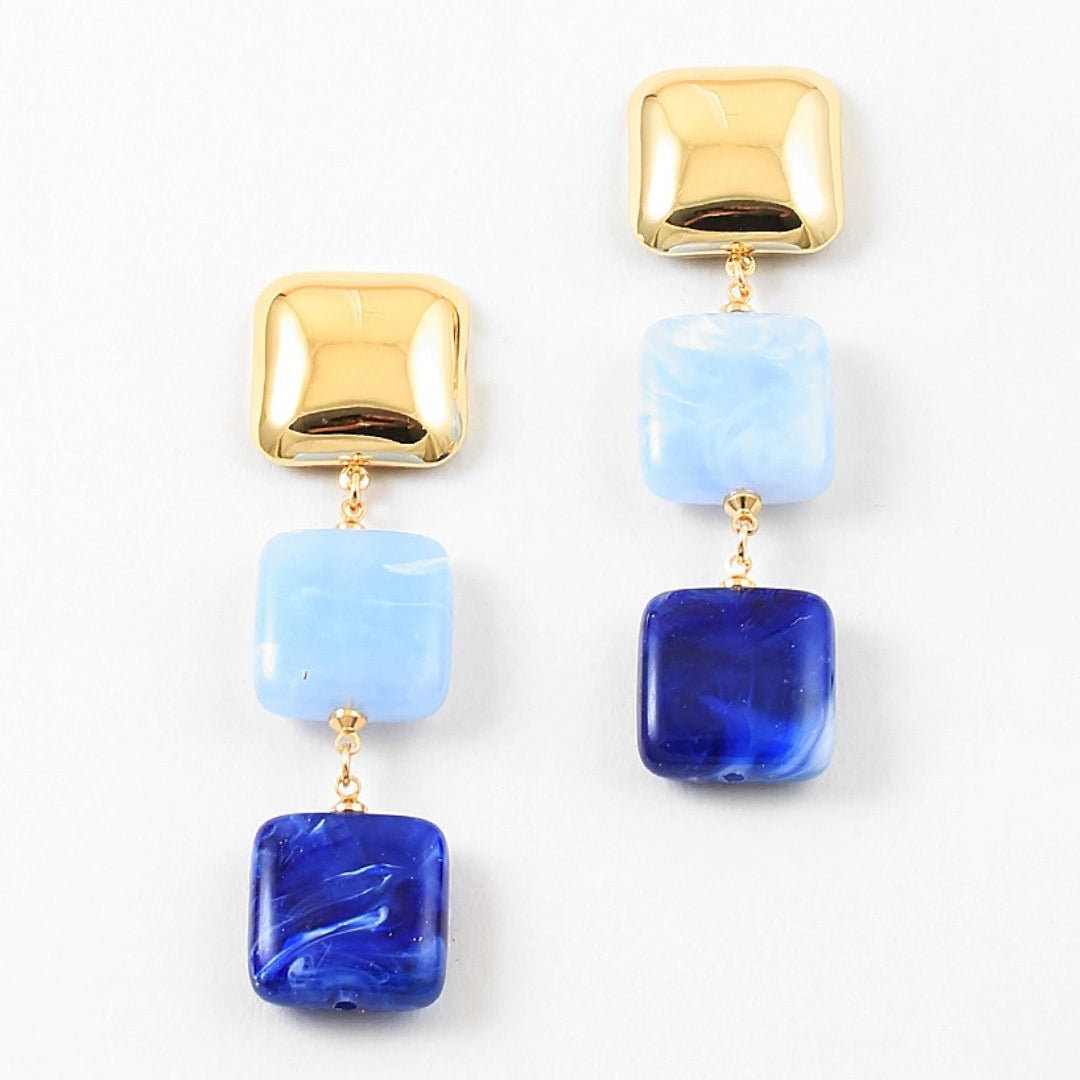 Gold and blue square bead dangle earrings on a white background