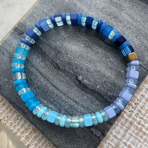 Picture of a blue ombre bead bracelet made of varying clear and solid beads.