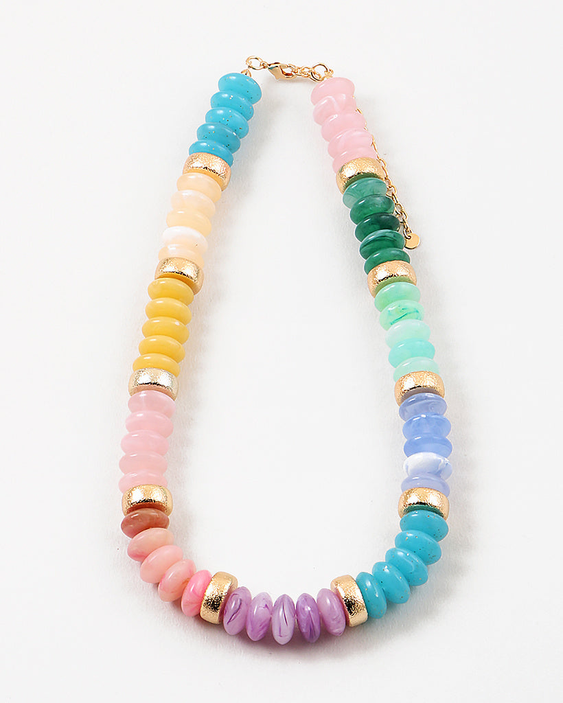 Picture of a chunky beaded necklace in greens, blues, inks and yellows. Necklace has a gold accent bead every 5th bead.