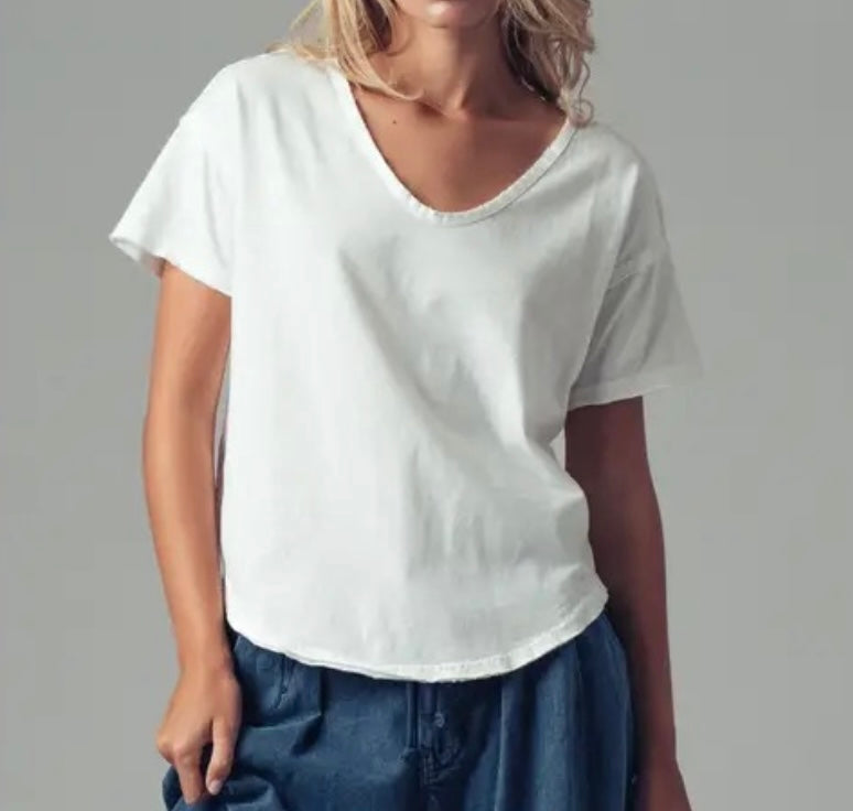 Person wearing a plain white t-shirt and blue pants on a gray background