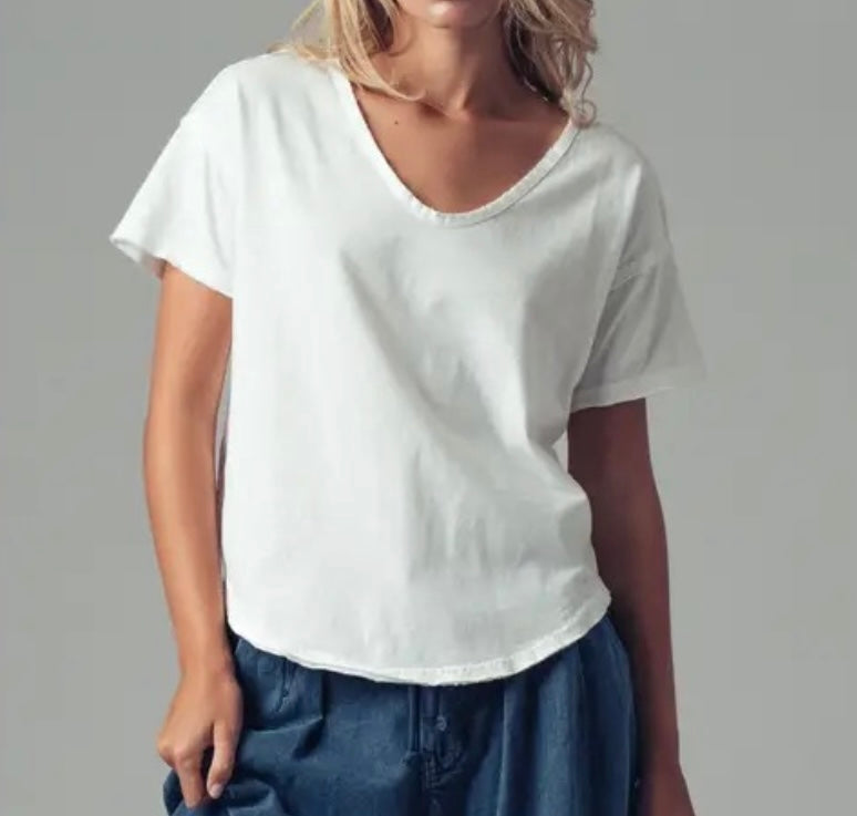 Person wearing a plain white t-shirt and blue pants on a gray background
