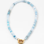Light blue bead necklace in varying shades of blue with a large gold carabiner clasp.