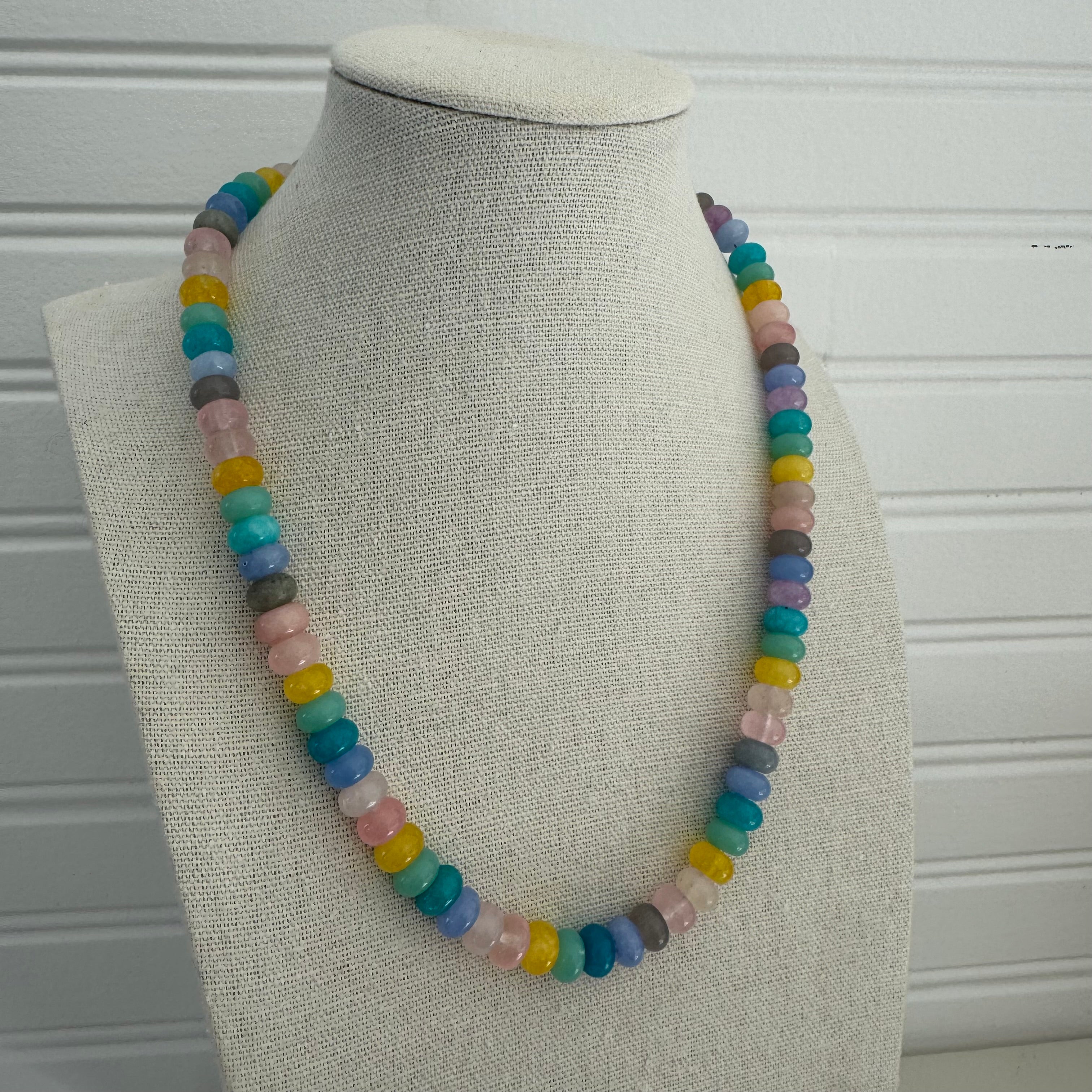 Picture of a necklace made of purple, blue, white, yellow and pink beads.