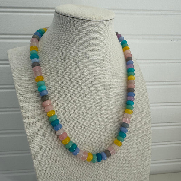 Picture of a necklace made of purple, blue, white, yellow and pink beads.