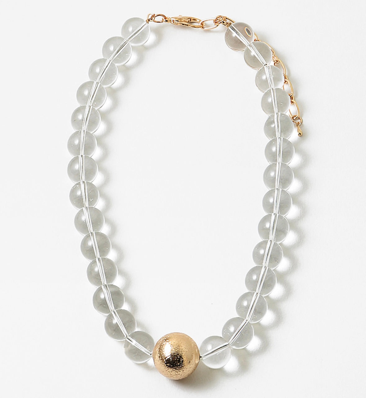 Necklace with clear beads and a gold ball pendant on a white background