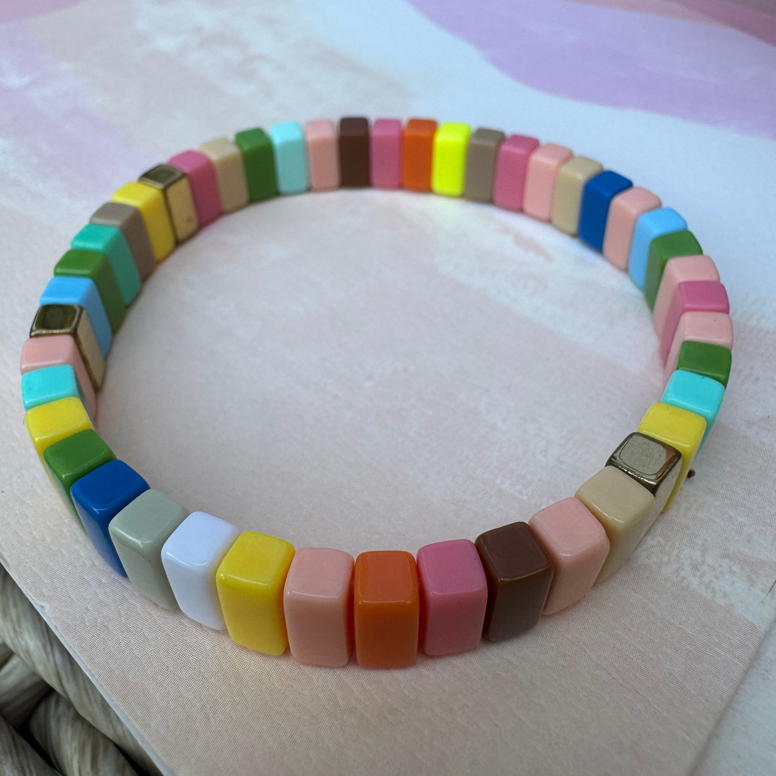Bead bracelet in muted colors of coral, orange, pink,maroon, tan, green, blues and yellow.