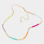 Necklace with colorful beads in pink, orange, teal, beige, gold and yellow beads on a white background
