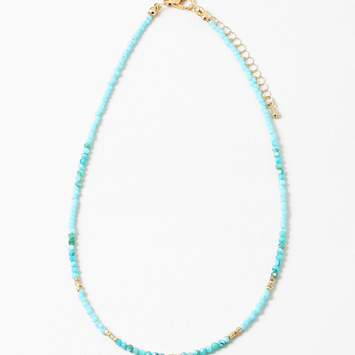 Delicate bead necklace with turquoise beads and small gold accent beads.