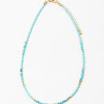 Delicate bead necklace with turquoise beads and small gold accent beads.