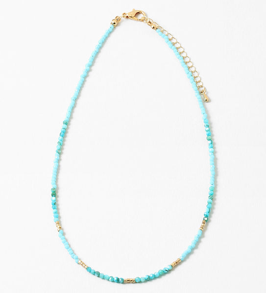 Delicate bead necklace with turquoise beads and small gold accent beads.