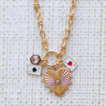 Picture of gold toggle chain with a large gold heart pendant with a diamond in its center,a blue bordered diamond charm, a an ace of spades charm and an ace of hearts charm.