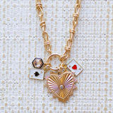 Picture of gold toggle chain with a large gold heart pendant with a diamond in its center,a blue bordered diamond charm, a an ace of spades charm and an ace of hearts charm.