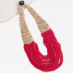 Necklace with beige and red bead strand sections on a white background