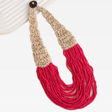 Necklace with beige and red bead strand sections on a white background
