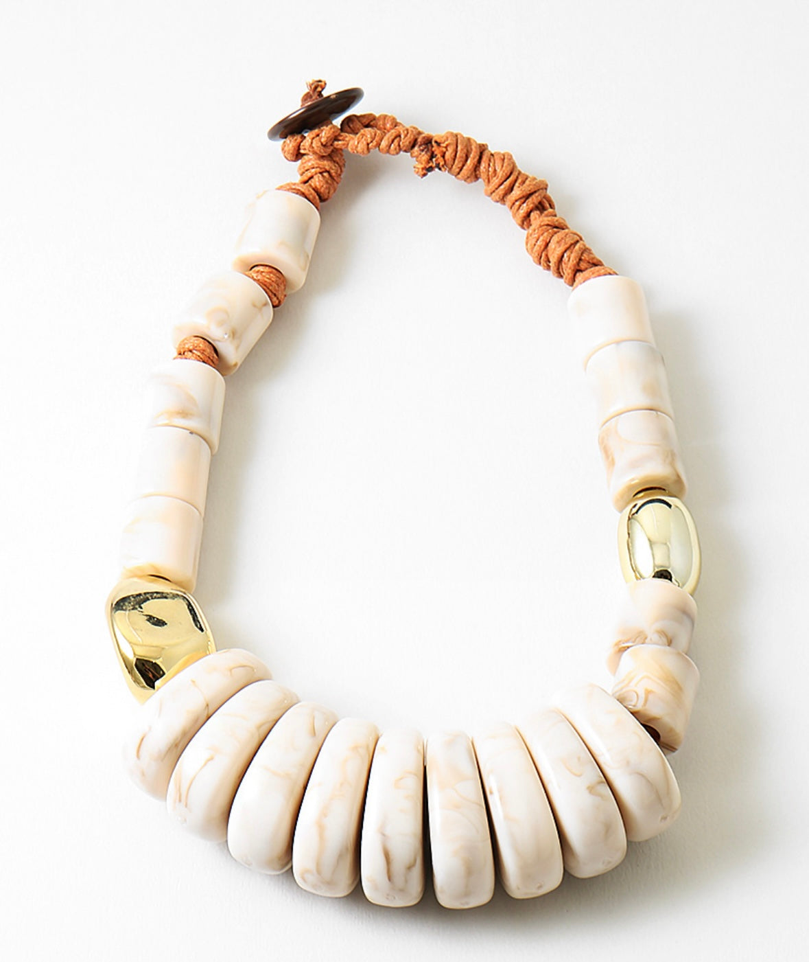 Large statement necklace with white beads and gold accents on a white background