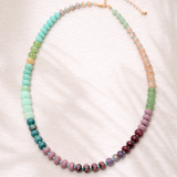 Multicolored green, coral and pink beaded necklace on a white background