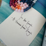 Note with handwritten text on a textured surface with beads