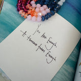 Note with handwritten text on a textured surface with beads