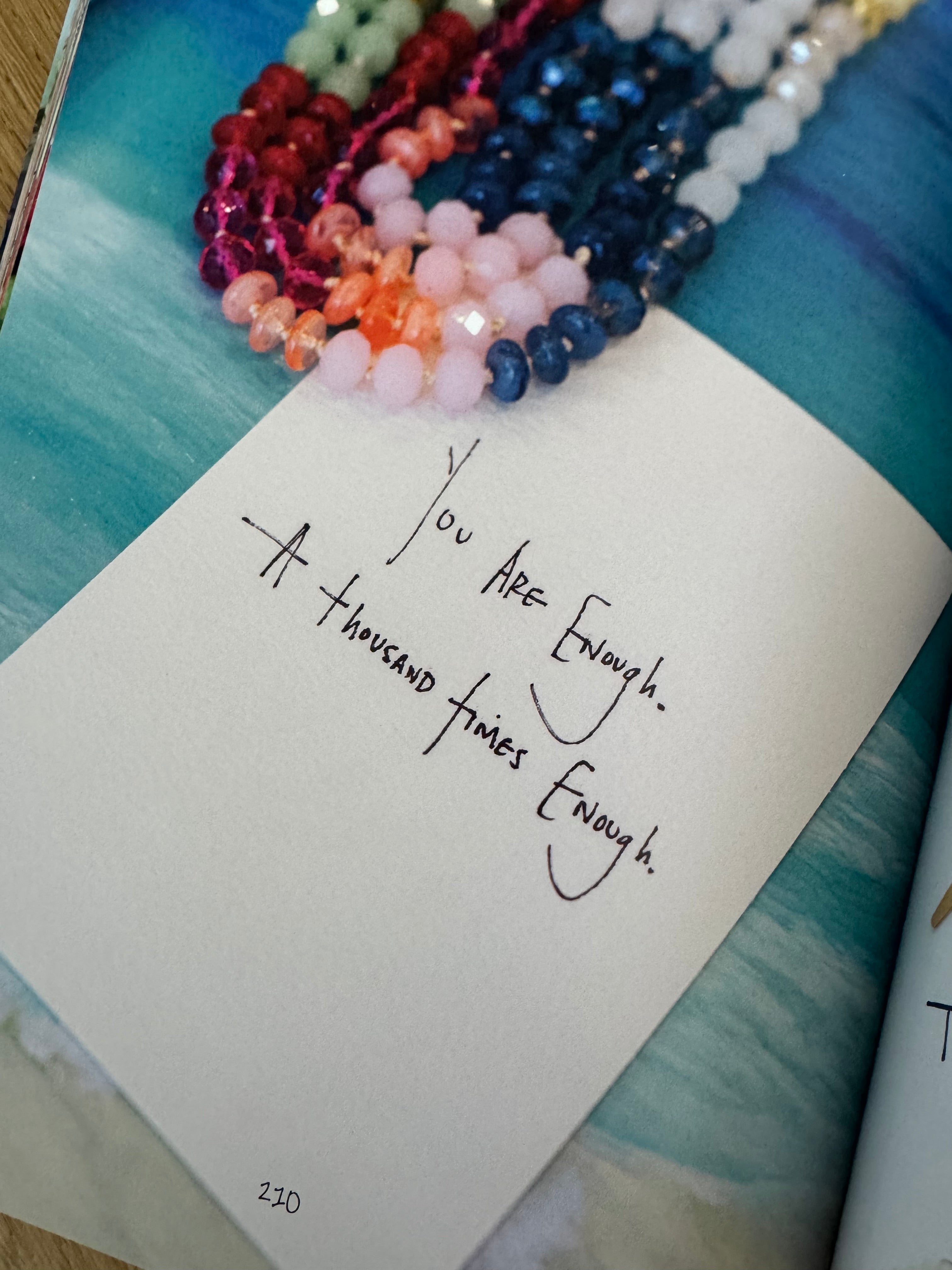 Note with handwritten text on a textured surface with beads