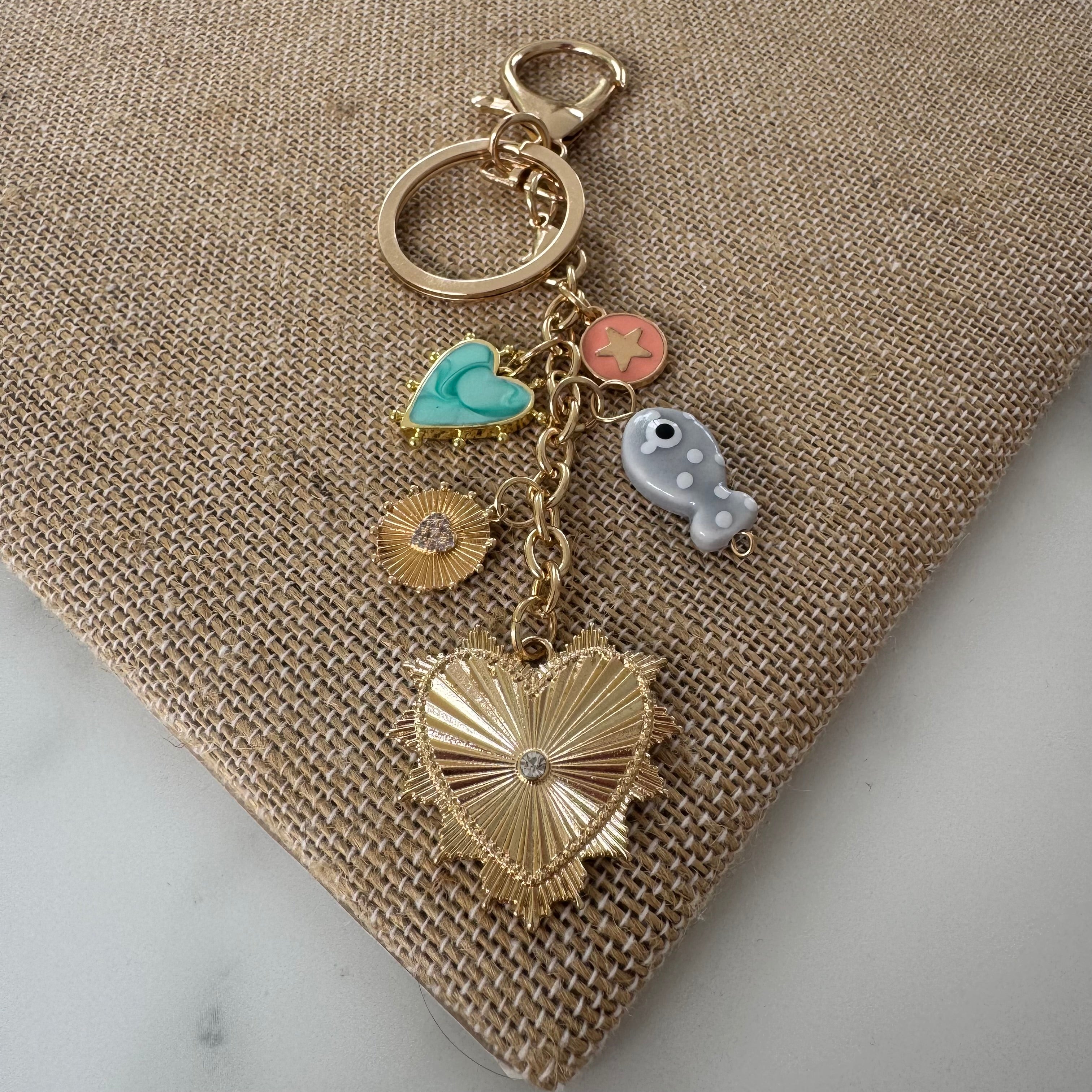 Keychain with heart-shaped charm and various other charms on a textured surface