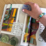 Person holding a colorful book with abstract designs on a wooden surface