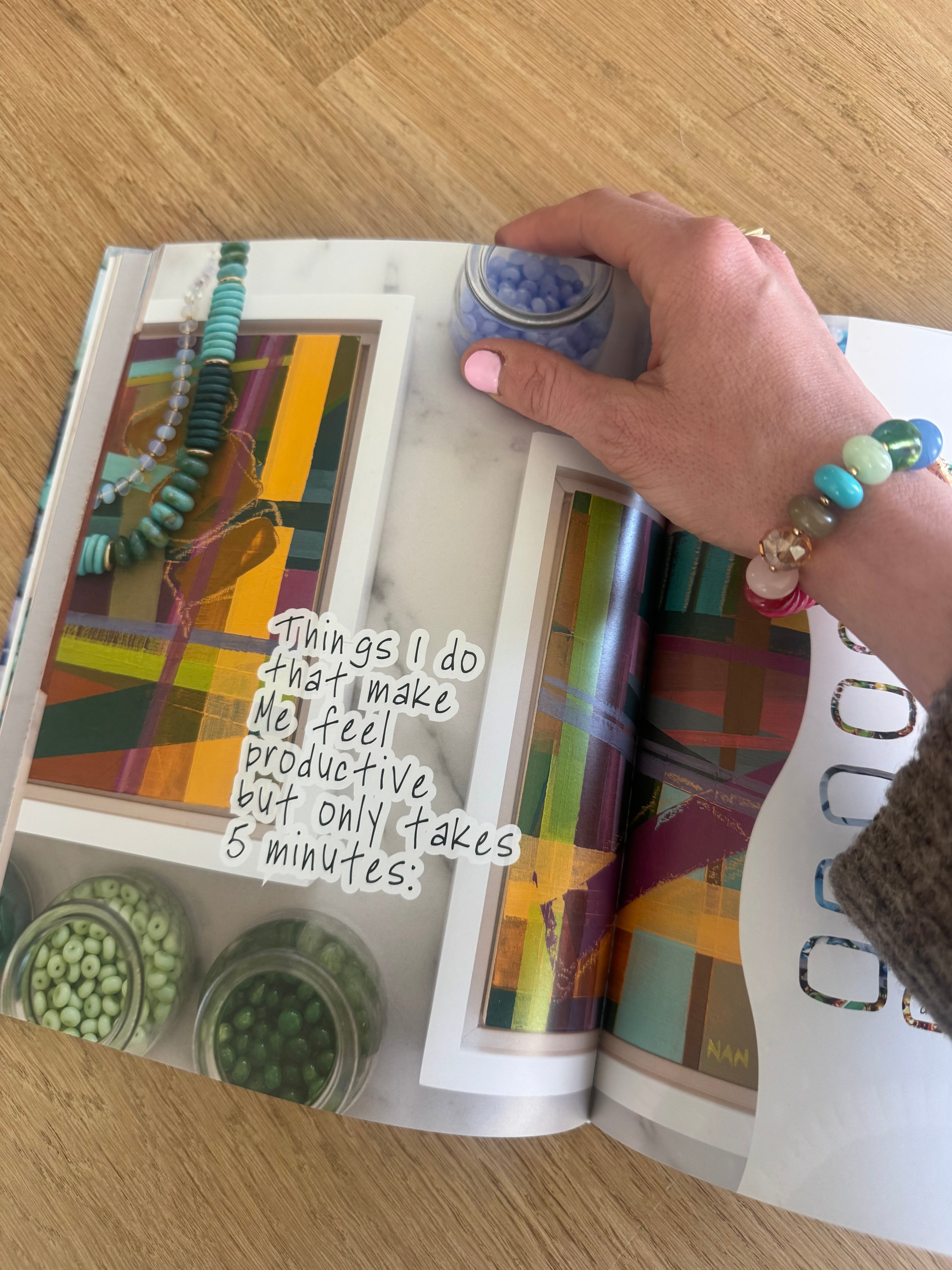 Person holding a colorful book with abstract designs on a wooden surface