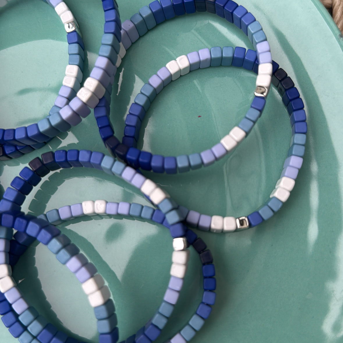 Picture of a plate holding 7 blue ombre bead bracelets