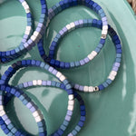 Picture of a plate holding 7 blue ombre bead bracelets