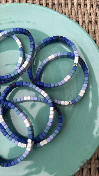 Picture of a plate holding 7 blue ombre bead bracelets