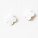 White stud earrings in the shape of rounded edge crosses.