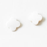 White stud earrings in the shape of rounded edge crosses.